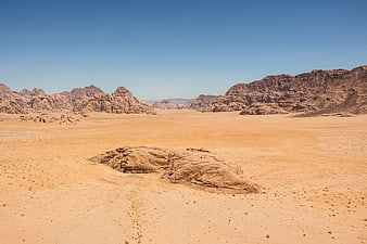 Vast Arid Desert Landscape With Erosion Rock Formations And Blue Sky