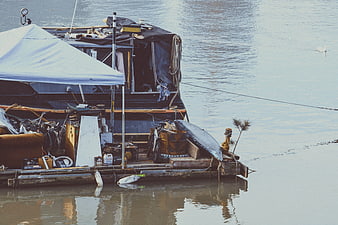 Cluttered Houseboat Docked on Calm River Water