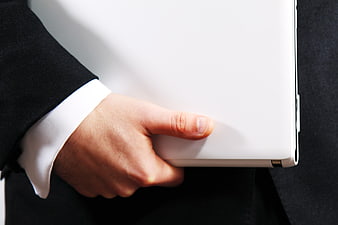 Businessman holding white laptop in black suit