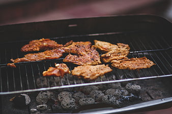 Seasoned pork steaks grilling over charcoal