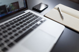 Laptop, Smartphone, and Notebook on a Desk