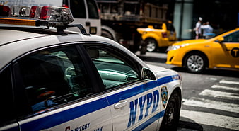 NYPD Police Car On New York City Street With Yellow Taxi