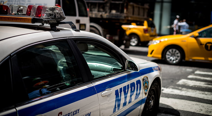 NYPD Police Car On New York City Street With Yellow Taxi