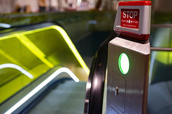 Escalator emergency stop button with green indicator light