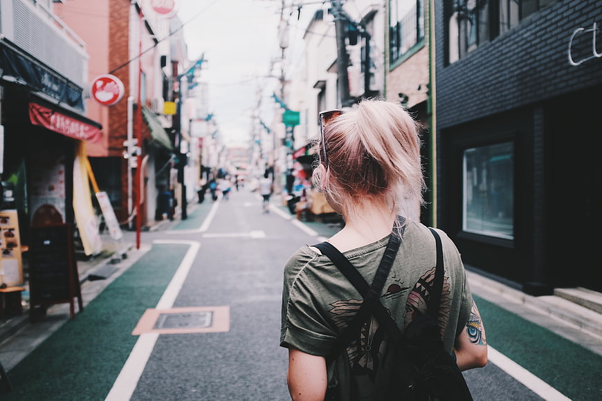Blonde Woman Walking Down Narrow Japanese Street