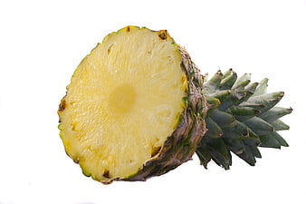 Cut pineapple slice with green crown on white background