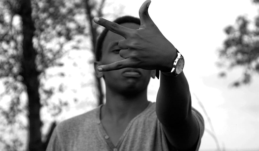Young man making hand gesture in black and white
