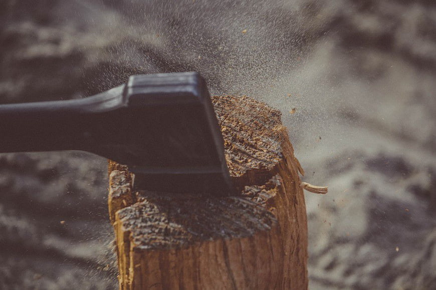 Axe Chopping Wood Log with Flying Sawdust