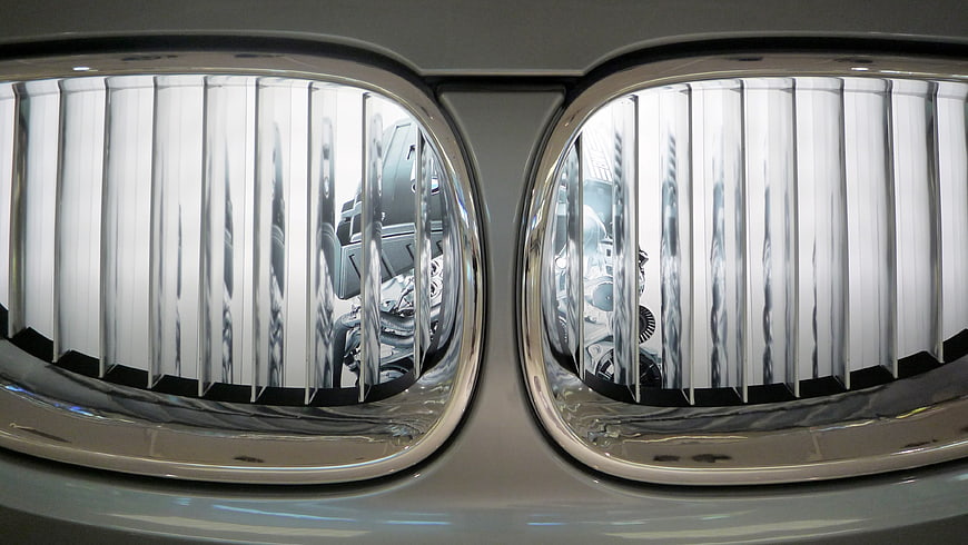 Close-up of Chrome Car Grille with Engine Reflection