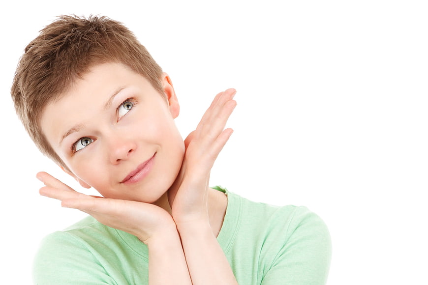 Young woman with short hair daydreaming on white background