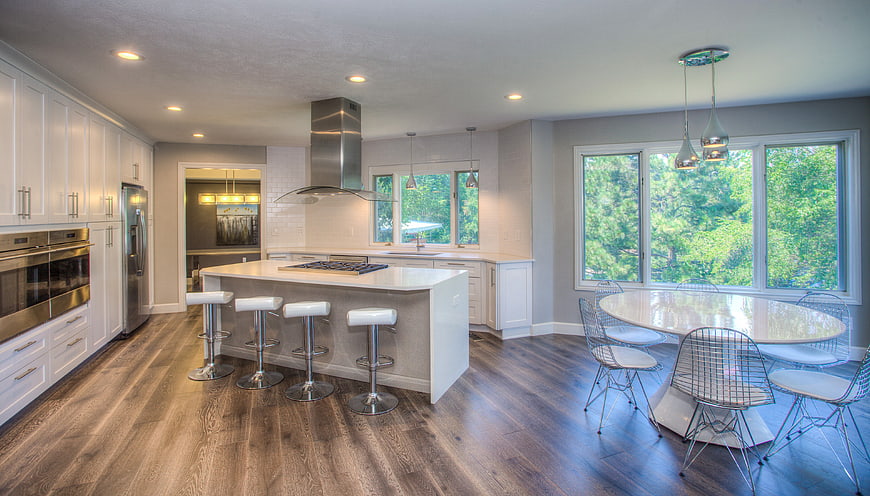 Modern kitchen with white cabinets, island, and dining area