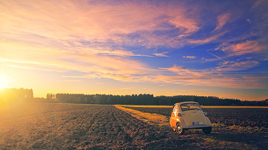 Vintage BMW Isetta in Plowed Field at Sunset