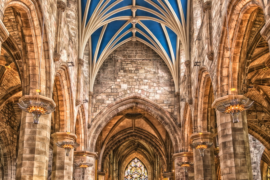 Gothic Cathedral Interior with Blue Vaulted Ceiling and Stone Arches