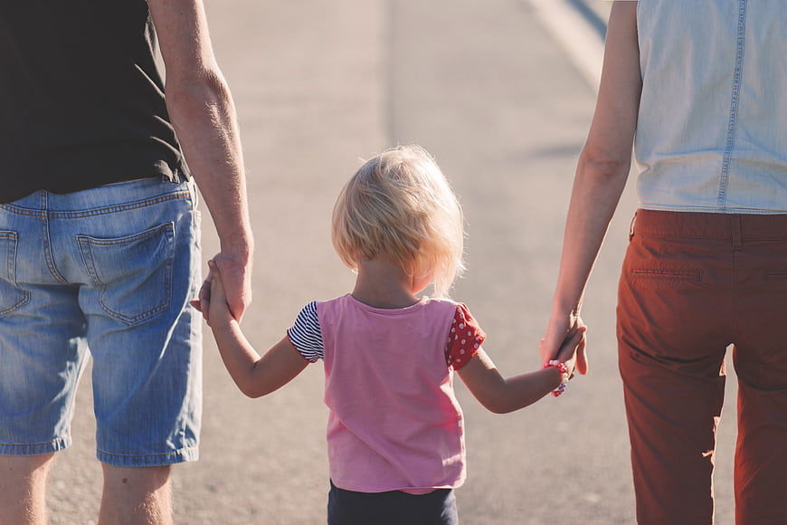 Family holding hands walking away outdoors
