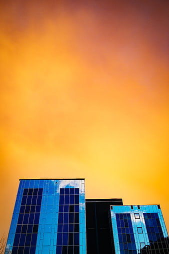 Modern Glass Buildings Against Vibrant Orange Sunset Sky