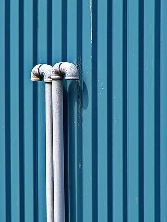 White Pipes on Blue Corrugated Metal Wall