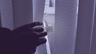 Hand Parting Sheer Curtains to Reveal Rainy Street View