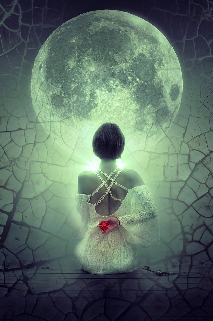 Mystical woman sitting before giant glowing green moon