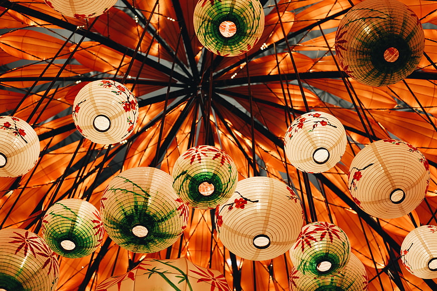 Colorful Japanese Paper Lanterns Hanging from Orange Umbrella Ceiling