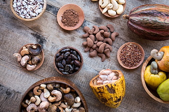 Top View of Cacao Pods, Cashews, and Cocoa Powder on Wood