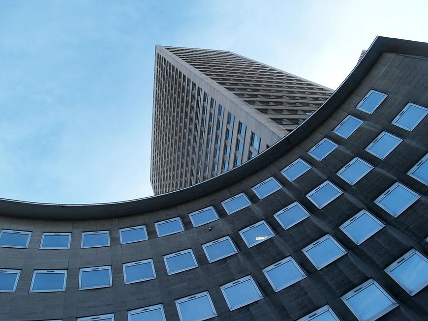 Low angle view of brutalist concrete architecture against blue sky