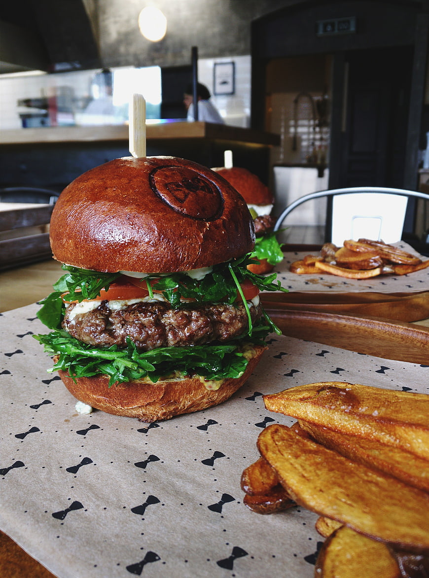 Gourmet beef burger with potato wedges on restaurant table