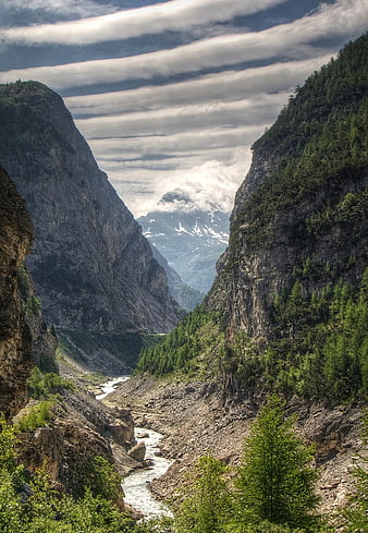 Dramatic Alpine Canyon with River and Snow-Capped Peaks