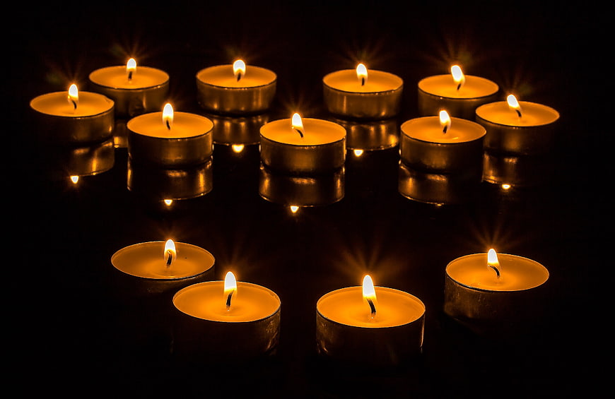 Tea light candles on black reflective surface