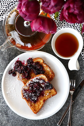 Overhead view of French toast with berry compote and tea