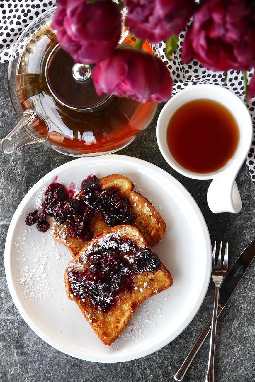 Overhead view of French toast with berry compote and tea