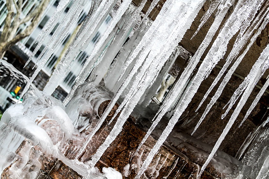 Close-up of sharp icicles hanging from a frozen fountain