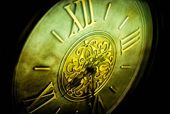 Close-up of vintage brass clock face with Roman numerals