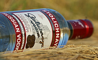 Stolichnaya Russian Vodka Bottle Lying On Hay In Field