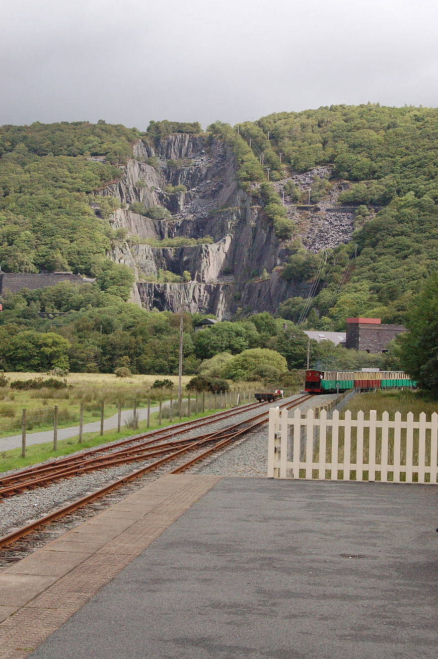Narrow Gauge Train Passing Slate Quarry in Snowdonia, Wales
