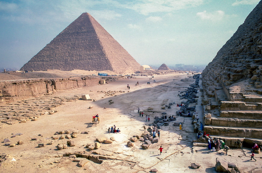 Wide View of Giza Pyramids with Tourists and Desert Landscape