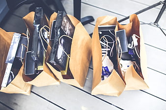 Brown paper shopping bags filled with gifts on wooden deck