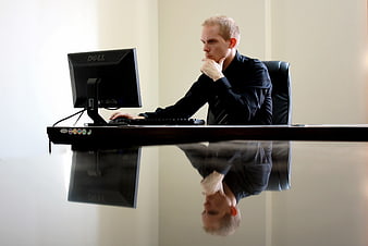 Businessman Thinking At Computer Desk With Reflection