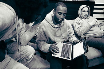 Three men collaborating on laptop in casual setting