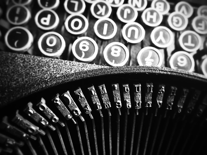 Close-up of vintage typewriter keys and mechanical typebars in black and white