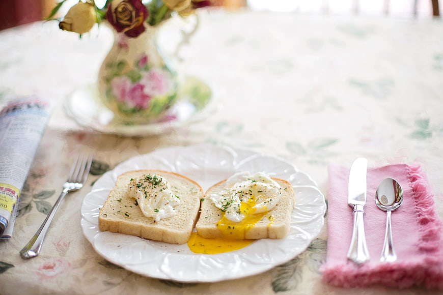 Poached eggs on toast breakfast with floral table setting