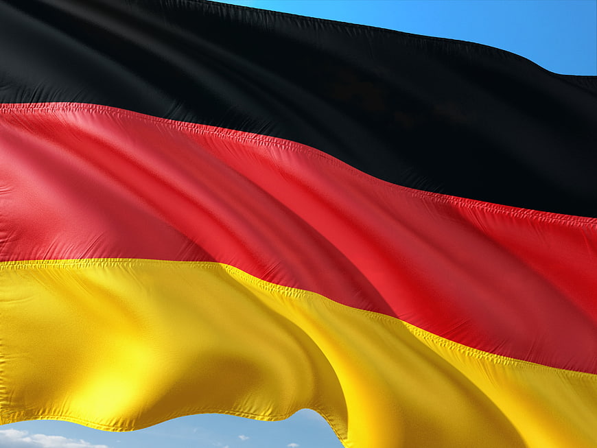 Close-up of the German flag waving against a clear blue sky