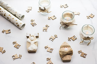 Christmas flat lay with wooden reindeer, candles, and wrapping paper
