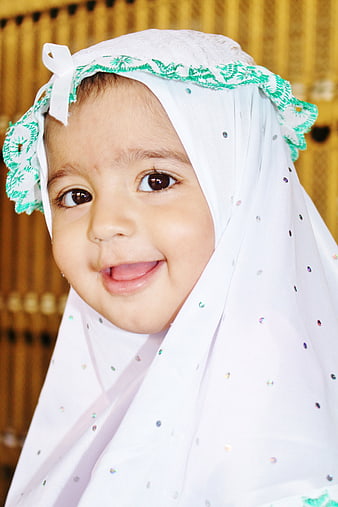 Happy Muslim girl wearing white hijab with green lace and rhinestones