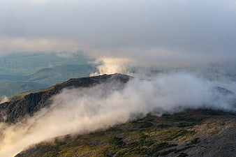 Misty mountain ridge with clouds rolling over rocky peaks