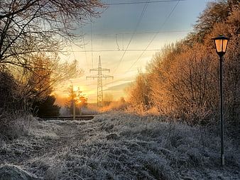 Frosty Winter Morning with Glowing Street Lamp and Sunrise