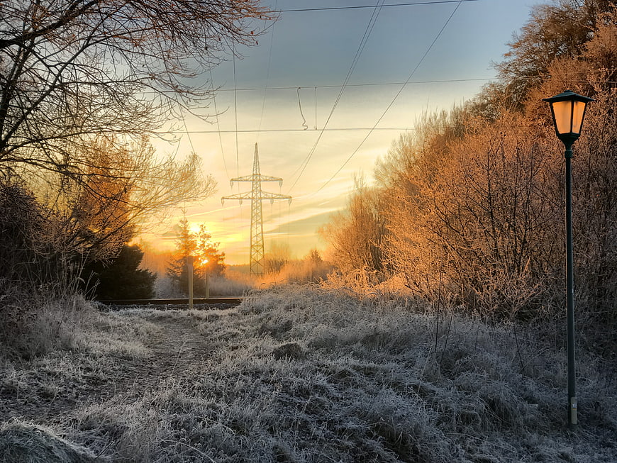 Frosty Winter Morning with Glowing Street Lamp and Sunrise