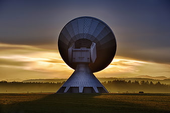 Large Satellite Dish Antenna at Sunrise in Misty Landscape