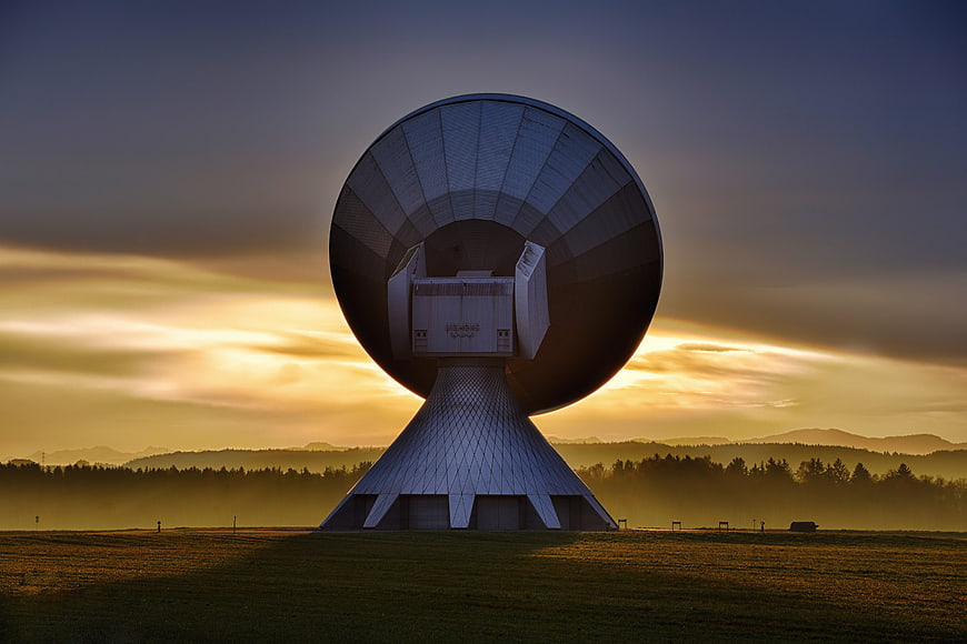 Large Satellite Dish Antenna at Sunrise in Misty Landscape