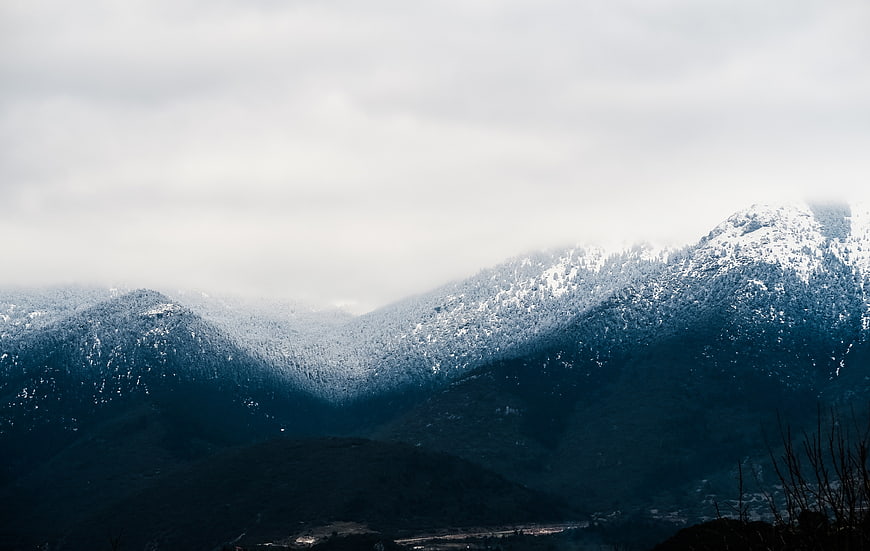 Misty Snow-Covered Mountain Peaks in Winter Landscape