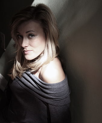 Portrait of Blonde Woman in Sunlight Against Wall